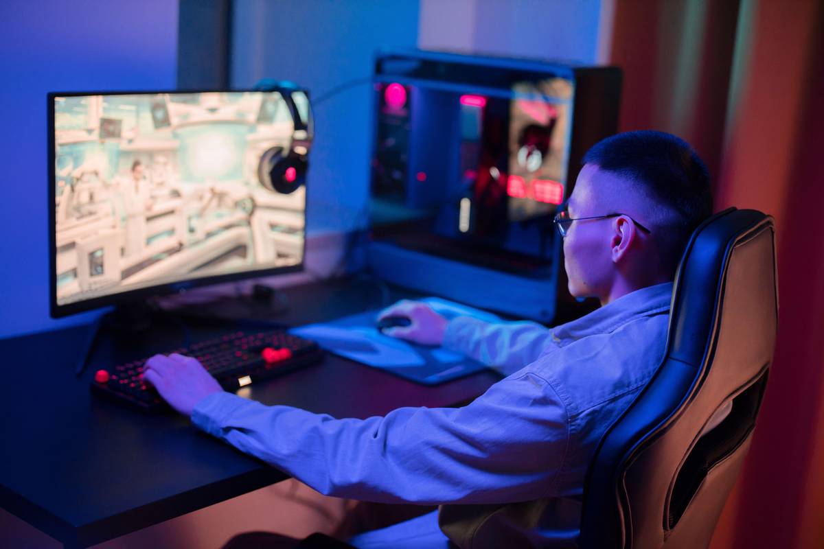 gaming room bed on top with dual monitors, LED strips, and cable management underneath
